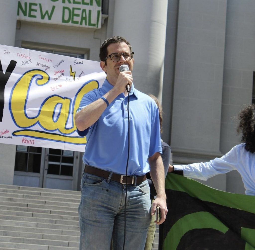 Igor Tregub, Candidate for Berkeley City Council Special Election May 28th, addresses Green New Deal crowd on steps of a large public building