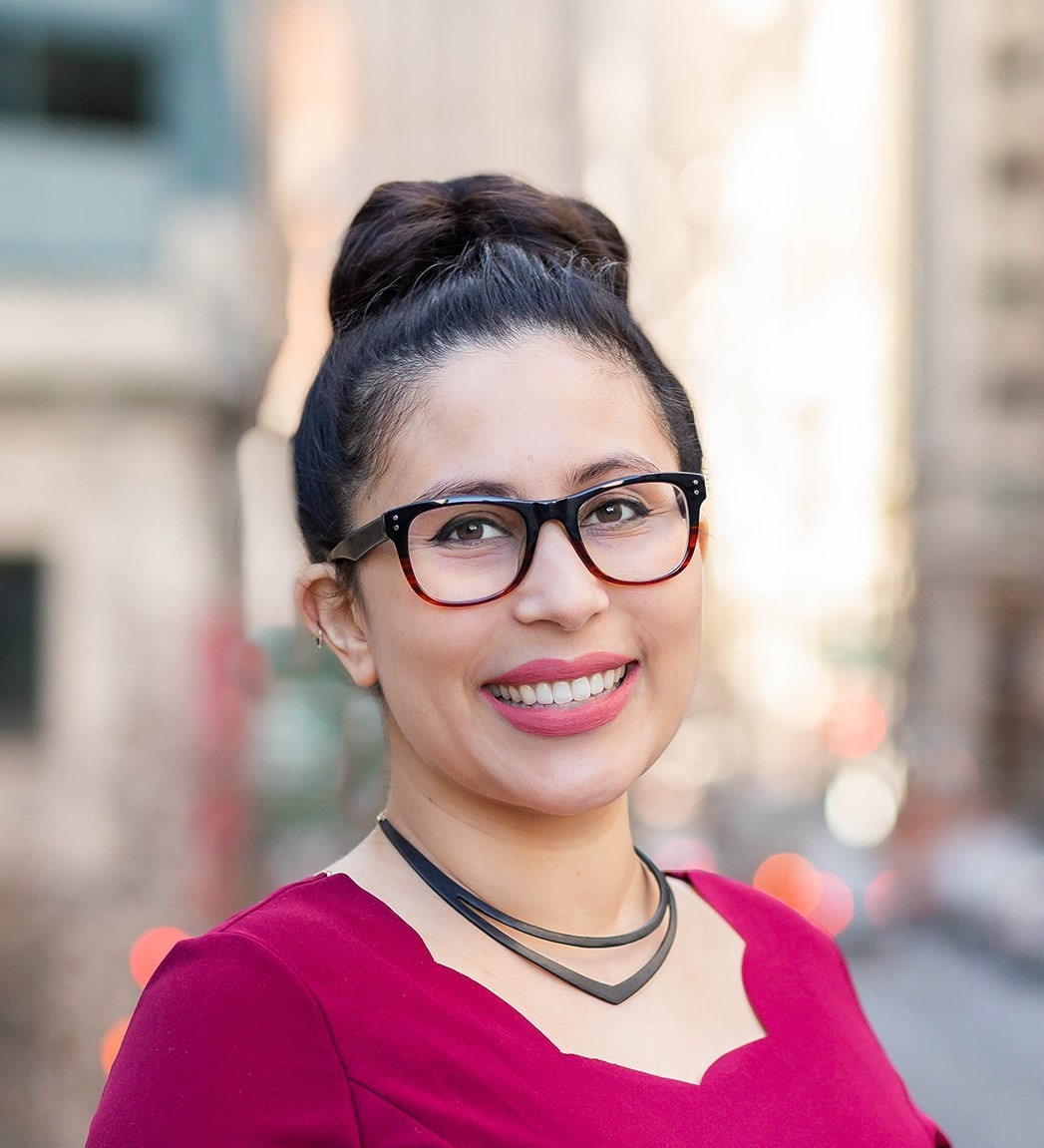 Aysha Pamukcu for South San Francisco District 1. Woman wearing fuchsia-rose blouse, smiling. Photo credit: Aysha Pamucku, used with permission.