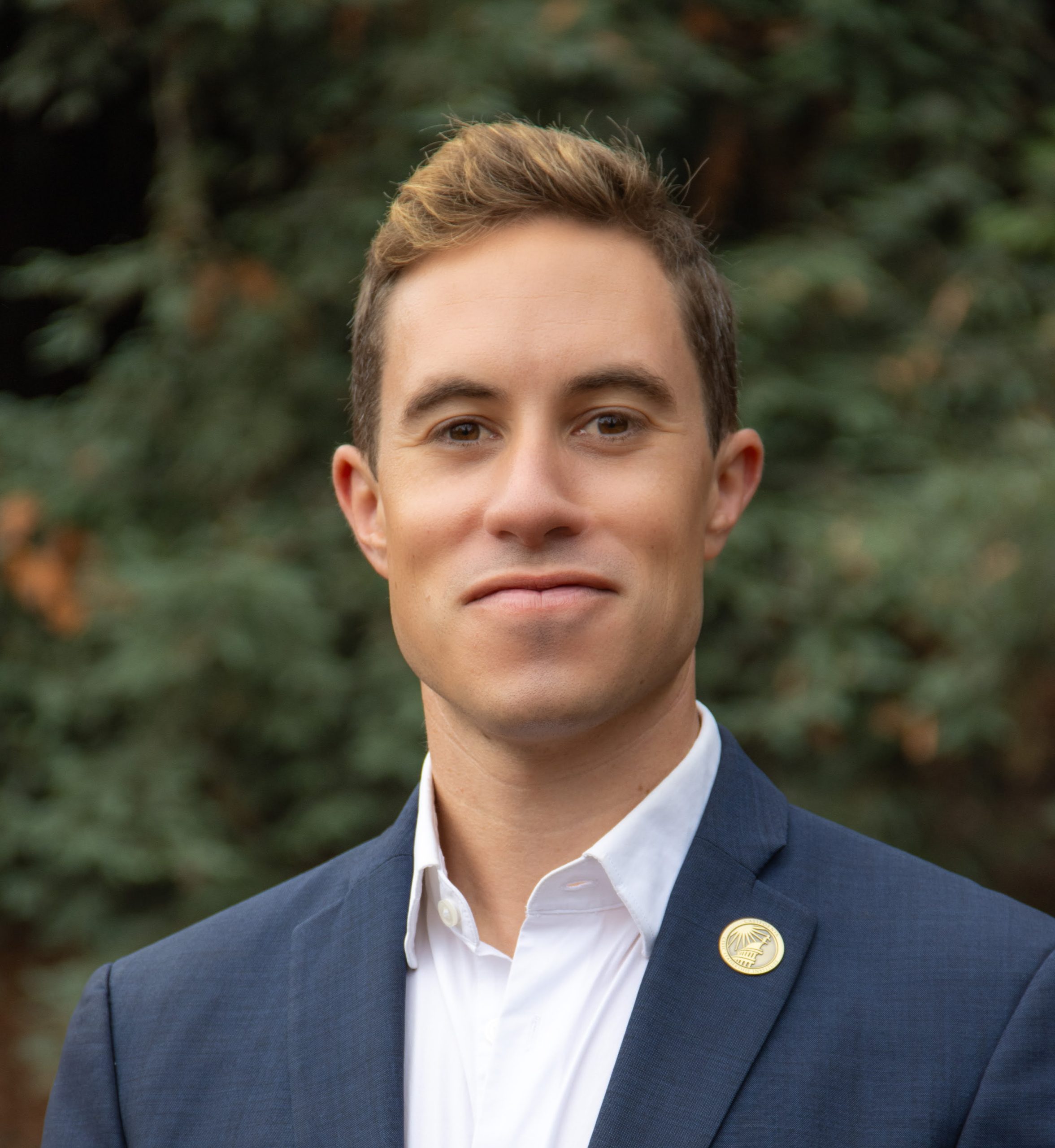 Eli Beckman for Corte Madera Town Council at Large. Eli is outside, wearing a blue suitcoat. Photo credit: Eli Beckman, used with permission.