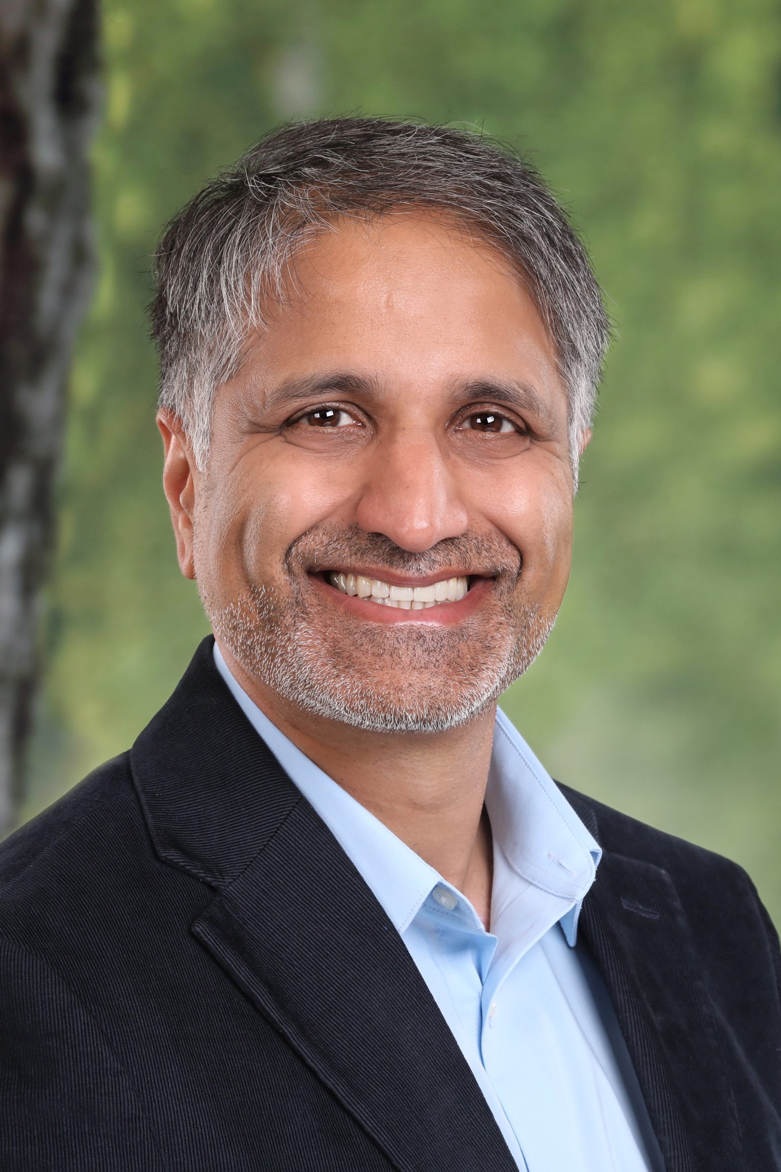 Vamsi Velagapudi for Menlo Park City Council District 2. Man in dark blue corduroy jacket and light blue shirt, smiling at camera. Photo credit: Vamsi Velagapudi, used with permission.