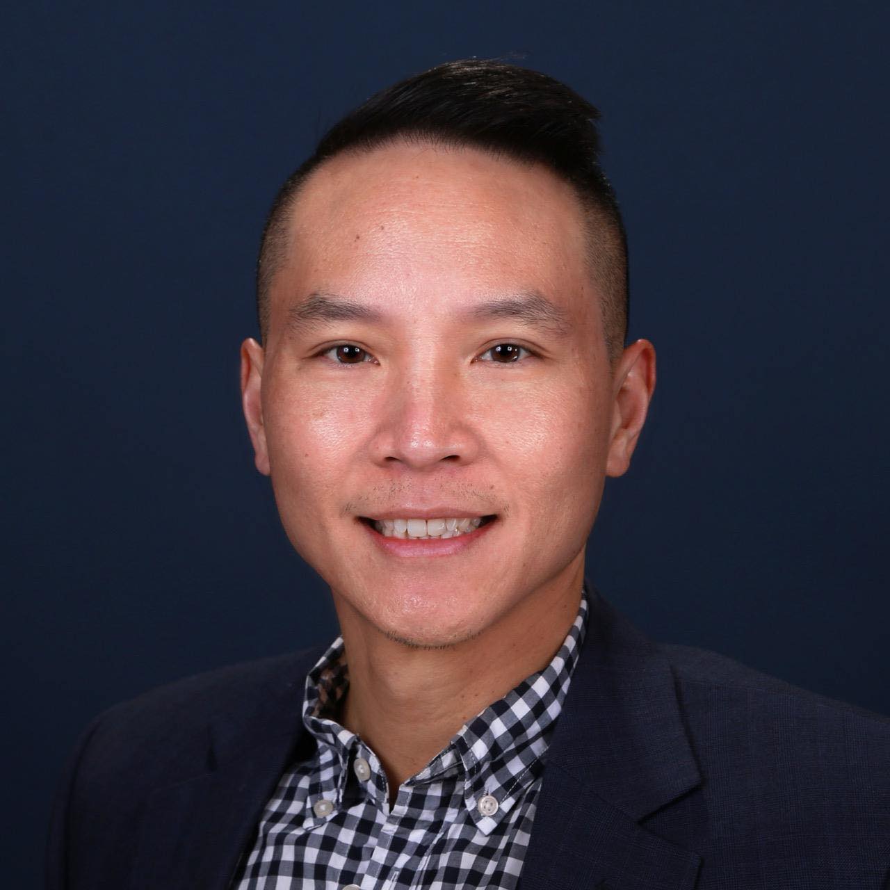 Kingsley Ma for San Bruno City Council District 1. Man in black suit coat and black and white checked shirt, smiling. Photo credit: Kingsley Ma, used with permission.